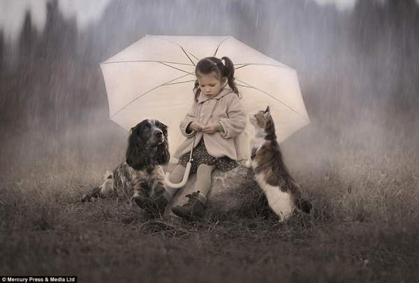 Девочка приютила двух животных под зонтиком в ненастную погоду