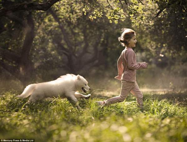 Девочка собакой играют в лесу