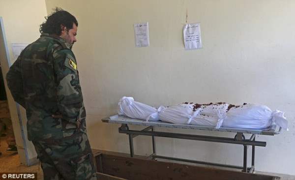 Ливийский солдат смотрит на мешок, где лежит его товарищ.