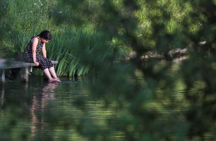 Девочка играет на береге озера